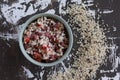 Top view of bowl with salad from tomato, cooked beans and mixed brown and black rice on the wooden background