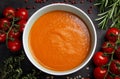 Top view of a bowl of tomato cream soup. The ingredients are arranged around the bowl: cherry tomato twigs, rosemary and thyme Royalty Free Stock Photo