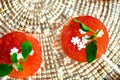 Top view of a bowl of watermelon popsicle treats decorated with fresh mint leaves