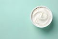 Top view of bowl with white quark or cream on side of mint green background with copy space