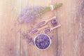 Top view of a bowl and wooden spoons with fresh lavender flowers and a bouquet of lavender on a brown wooden background Royalty Free Stock Photo