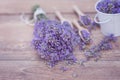 Top view of a bowl and wooden spoons with fresh lavender flowers and a bouquet of lavender on a brown wooden background Royalty Free Stock Photo