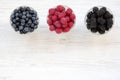 Top view, bowls containing berries: blueberries, blackberries, raspberries. Healthy eating and dieting. From above, overhead.