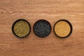 Top view of bowls with legumes and cereal on wooden surface.