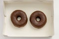 Top view of a box with two chocolate covered donuts Royalty Free Stock Photo