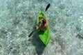 Young happy man kayaking on a tropical island in the Maldives. Clear blue water