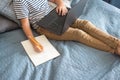 Top view on boy writing or drawing and using his laptop while doing homework. Studying online during quarantine, online Royalty Free Stock Photo