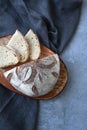 Top view of bread half and slices on ceramic plate on grey fabric and wood backround vertical Royalty Free Stock Photo