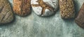 Top view of bread loaves over grey background, wide composition Royalty Free Stock Photo