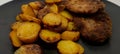 Top view of breaded vienna schnitzel with baked potatoes on a dark plate, European cuisine Royalty Free Stock Photo