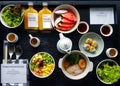 Top view of breakfast with fresh salad, dim sum, noodle with boiled pork, watermelon, dragon fruit, bottle of orange juice