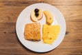 Top view of Breakfast menu: Omelette, Croissant sandwich, banana, apple and grapes in white plate on wooden table. Royalty Free Stock Photo