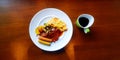 Top view of breakfast with omelet, bacon, many sausage, fried vegetable and tomato or chili sauce with green cup of black coffee. Royalty Free Stock Photo