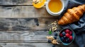 Delicious breakfast setup on a wooden table with fresh croissant, berries and juice. cozy morning meal, simple rustic Royalty Free Stock Photo
