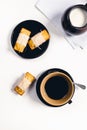 Breakfast table with cup of coffee milk and cakes on white background