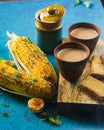 Hot freshly brewed milk tea with roasted grilled corn and fresh toast. Delicious Grilled Corncobs and Two Cups of Masala Chai.