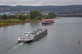 Top view from a bridge across the river rhine onto a tank vessel with a container ship in background