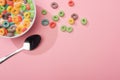 Top view of bright colorful breakfast cereal with milk in bowl near spoon Royalty Free Stock Photo