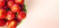 Top view of bright freshly picked strawberries on pink background