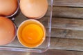 top view of broken eggshell with yellow yolk near eggs in plastic box Royalty Free Stock Photo