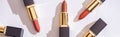 Top view of brown assorted lipsticks in luxury tubes on white background, panoramic shot