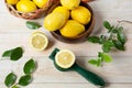 Top view of a brown bowl of whole lemons next to sliced lemon and a juice squeezer Royalty Free Stock Photo