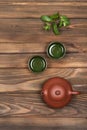 Brown ceramic teapot, two dark green small special cups and fresh mint on a dark wooden planked background. Tea ceremony. Royalty Free Stock Photo