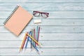 Top view of brown closed cover blank notebook with eyeglasses and various colorful pencil on wood table background Royalty Free Stock Photo