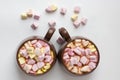 Top view of brown cups of hot cocoa with marshmallows in heart shape on white background Royalty Free Stock Photo