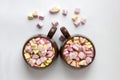 Top view of brown cups of hot cocoa with marshmallows in heart shape on white background Royalty Free Stock Photo