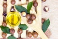 Top view of brown macadamia nuts with yellow oil in a glass bowl on light wooden background. Royalty Free Stock Photo