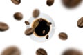 Top view of brown roasted coffee beans falling and flying to coffee cup on white background. Royalty Free Stock Photo