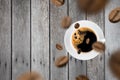 Top view of brown roasted coffee beans falling and flying to coffee cup.Represent breakfast for energy and freshness concept Royalty Free Stock Photo