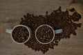 Top view of brown roasted coffee beans spilled on a table with a full coffee mug Royalty Free Stock Photo