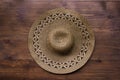 Top view of brown rustic straw hat on wooden background. Summer vacation rural concept. Close-up of accessory of clothing women Royalty Free Stock Photo
