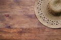 Top view of brown rustic straw hat on wooden background. Summer vacation rural concept. Close-up of accessory of clothing women Royalty Free Stock Photo