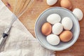 Top view brown and white eggs in a bowl and on cooking desk with a metal whisker and a cloth aside Royalty Free Stock Photo