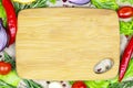 Top view of brown wooden cutting board with summer vegetables and champignon mushroom on table background. Royalty Free Stock Photo