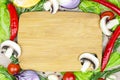 Top view of brown wooden cutting board with summer vegetables and champignon mushroom on table background. Royalty Free Stock Photo