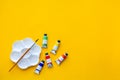 Top view of brushes, color tubes and palette on yellow background, copy space, flat lay, paintings art concept