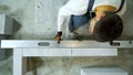 Top view of builder checking evenness of aerated concrete wall with spirit level