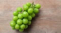 bunch of fresh sweet green shine muscat (vitis vinifera) grape isolate on a wooden background. japanese grapes. Royalty Free Stock Photo