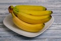 Top view of Bunch of organic banana fruits is on a white porcelain plate Royalty Free Stock Photo