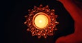 Top view of a burning candle in a beautiful sun-shaped candlestick base in the darkness Royalty Free Stock Photo