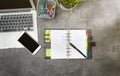 Top view of business desk with laptop, potted plant, notebook, mobile phone and business accessories