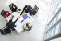 Top view of business partners shaking hands over the table after concluding a business agreement in meeting room with the team. Royalty Free Stock Photo