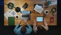 Top view of business people working on computer at desk with paperwork in home office. Royalty Free Stock Photo