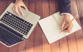 Top view business woman write on notebook and use laptop working outdoor in coffee shop vintage tone Royalty Free Stock Photo