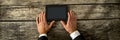Top view of businessman hands holding black digital tablet