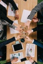 Top view of businesspeople clang glasses together at table